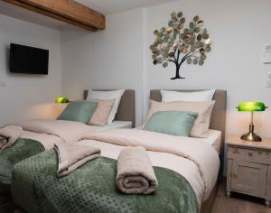 a bedroom with two beds with towels on them at chambresdusoleil in Hoffen