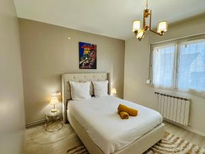 Un dormitorio con una cama con un osito de peluche encima. en La Maison de Mickey - Disneyland Paris, en Bailly-Romainvilliers