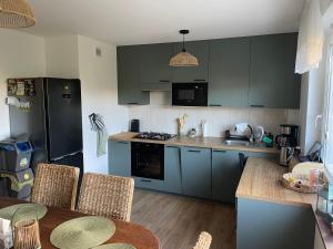 una cocina con armarios verdes y una mesa con sillas en Święty Spokój, en Gdansk