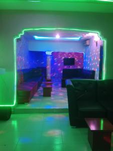 una habitación con sofás y una habitación con luces moradas en Grandsheffield 8 hotel, en Mama