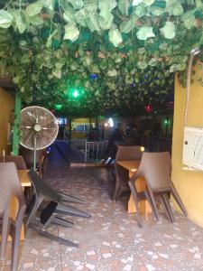 un restaurante con mesas y sillas y un techo con plantas en Grandsheffield 8 hotel, en Mama