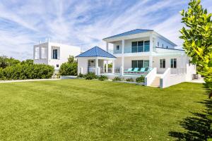 a large white house with a large yard at New Unique Villa Blue Top! 2 Bedroom Waterfront in Providenciales
