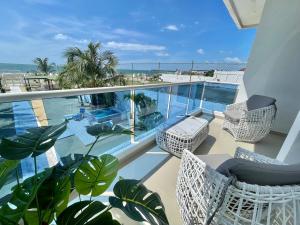 a balcony with chairs and a view of the ocean at Exclusiva Villa frente a la playa in Cartagena de Indias