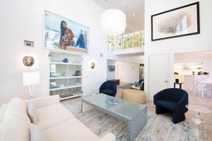 a living room with a white couch and a table at Flip Flop Kai - Family Beach House with Pool, Hot Tub, and Dock on Bio Bay in Driftwood Village +20 photos