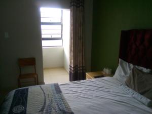 un dormitorio con una cama y una ventana en Anderson Lodge, en Goodwood