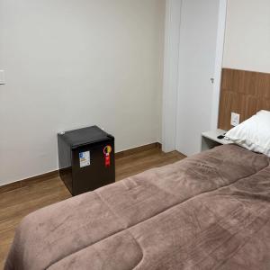 a bedroom with a large bed and a black box at Restaurante e Pousada Andrade 