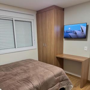 a bedroom with a bed and a flat screen tv at Restaurante e Pousada Andrade 