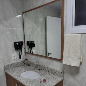 a bathroom with a sink and a mirror at Restaurante e Pousada Andrade 
