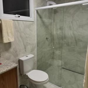 a bathroom with a toilet and a glass shower at Restaurante e Pousada Andrade 