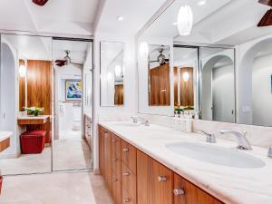 a bathroom with two sinks and two mirrors at Polo Beach Club 301 in Wailea +25 photos