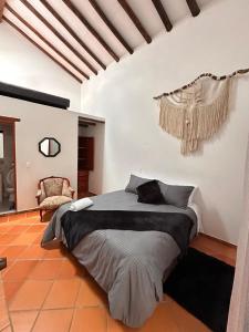 Un dormitorio con una cama grande y una silla. en LeyvaYork Apartasuites, en Villa de Leyva