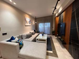 a living room with a couch and a tv at The Bluestone Stay - Heart of Tangier's Corniche in Tangier