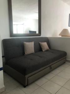 a couch with two pillows on it in a room at studio Opa in Puerto Vallarta