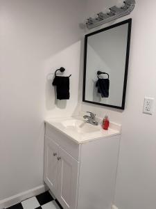 Un baño blanco con lavabo y espejo. en 80s & 90s Apt with Mario Loft, en Lake Catherine