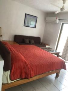 a bedroom with a red bed and a couch at studio Opa in Puerto Vallarta +16 photos