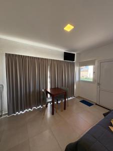 ein Wohnzimmer mit einem Tisch und einem Fenster in der Unterkunft Monoambiente acogedor cerca de playa en Miramar in Miramar + 6 Fotos