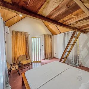 - une chambre mansardée avec un lit et une échelle dans l'établissement ambayard, 