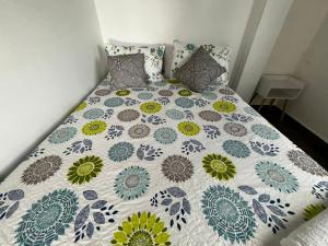 a bed with a quilt on it with two pillows at Villa Paraíso Nápoles in Doradal