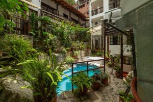 a courtyard with a swimming pool in a building with plants at Gringo Bill's Boutique Hotel in Machu Picchu