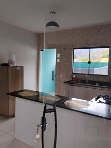 cocina con encimera con 2 lavabos y ventana en Casa Vale dos Peões Lumiar 2, en Nova Friburgo