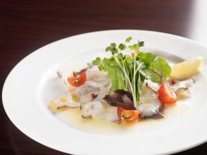 ein weißer Teller mit Lebensmitteln auf einem Tisch in der Unterkunft Pension Alhambra - Vacation STAY 15537v in Manazuru