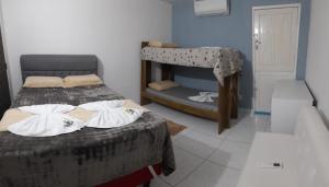 een slaapkamer met 2 bedden en een stapelbed bij Hospedaria Temporarte in Piranhas
