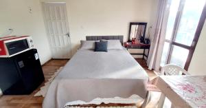 a bedroom with a large bed in a room at KITNET k3 em TORRES-RS - Na mais bela praia Gaúcha - Frigobar - micro-ondas - Banheiro - Ar condicionado split - TV smart - Wi-Fi - Anfitriã SuperHost no BNB in Torres +29 photos