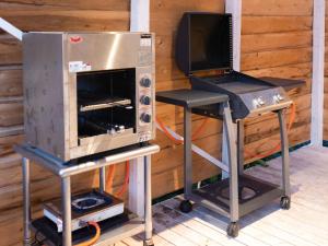 ein Backofen und ein Grill mit einem Barhocker in der Unterkunft Pension Alhambra - Vacation STAY 15537v in Manazuru