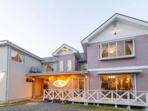 ein Haus mit einer großen Veranda in der Unterkunft Pension Alhambra - Vacation STAY 15537v in Manazuru