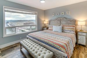 Un dormitorio con una cama y una ventana grande. en Waterfront Clear Lake Home with Game Room and Deck!, en Nice