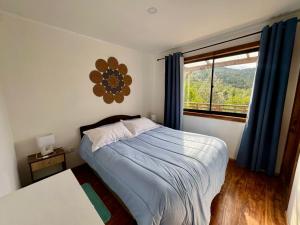 a bedroom with a bed and a large window at Casa con vista al rio Cutipay in Niebla