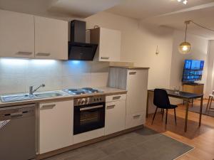 a kitchen with a stove and a sink and a table at K&K City-Apartment in Weimar
