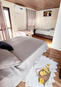 a bedroom with a bed with a pineapple motif on it at KITNET k3 em TORRES-RS - Na mais bela praia Gaúcha - Frigobar - micro-ondas - Banheiro - Ar condicionado split - TV smart - Wi-Fi - Anfitriã SuperHost no BNB in Torres