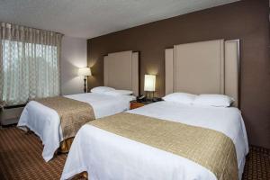 a hotel room with two beds and a window at Three Rivers Motel in Fort Wayne
