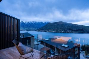 a balcony with a table and chairs and a mountain at Olive Tree House Lake Mountain Views Garage in Frankton Wharf