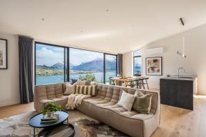 a living room with a couch and a large window at Olive Tree House Lake Mountain Views Garage in Frankton Wharf