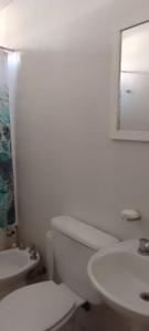 a white bathroom with a toilet and a sink at Departamento luminoso amplio in San Antonio de Areco
