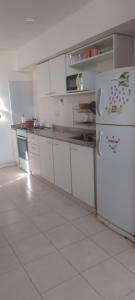 a kitchen with white cabinets and a refrigerator at Departamento luminoso amplio in San Antonio de Areco