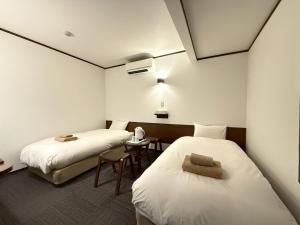 une chambre avec deux lits et une table dans l'établissement Hakodate City - Hotel - Vacation STAY 40640v, à Naka-hamachō
