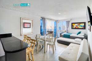 a living room with a table and a bedroom at Maralago el Conquistador Apartamentos Cartagena in Cartagena de Indias