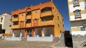 a orange building with balconies on the side of it at Melia house in Marsa Alam City
