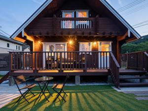 a large wooden house with a deck and chairs at Villa & Sauna - NAGIOTO - - Vacation STAY 20253 in Fujinowaki