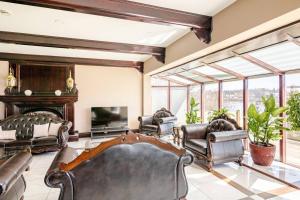 a living room with leather furniture and a fireplace at Waterfront Mansion with River & Mountain View, 40 Minutes from Montreal in Beloeil Village