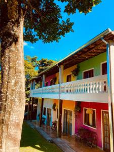 a colorful house with a tree in the foreground at Pousada Maria Laura in Guararema +4 photos