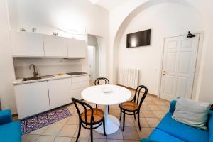 a living room with a table and chairs and a kitchen at Casa La Turchese in Gualdo Tadino