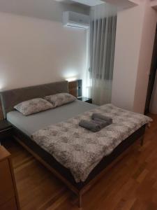 a bed with two pillows on it in a bedroom at Centar Crnjanski 1 in Jagodina +18 photos