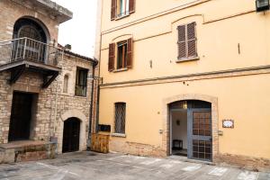 - un ancien bâtiment avec une porte et un balcon dans l'établissement Casa La Turchese, à Gualdo Tadino