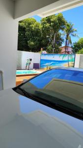 a car parked in front of a swimming pool at Pousadinha Litoral in Mucuri
