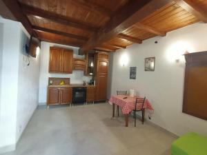 a kitchen with wooden cabinets and a table at Le coste sul lago in Montefiascone