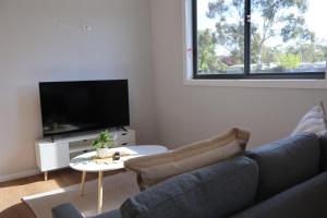 a living room with a couch and a tv at Proline Serviced Apartments 